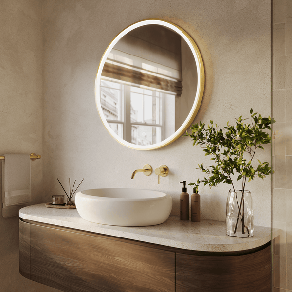 Runder LED Badezimmerspiegel mit Beleuchtung und goldenem Rahmen über einem Waschtisch mit Aufsatzwaschbecken und Holzelementen.