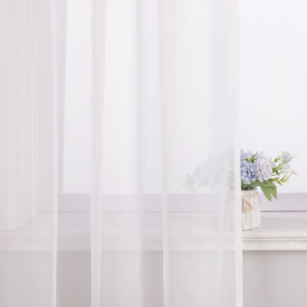 Dekoschals vor Fenster mit Blumenvase