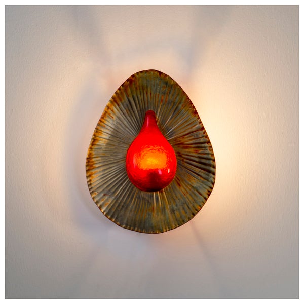 Dekorative Wandleuchte mit einem roten, tropfenförmigen Glas in der Mitte eines gerippten, blattförmigen Metalls