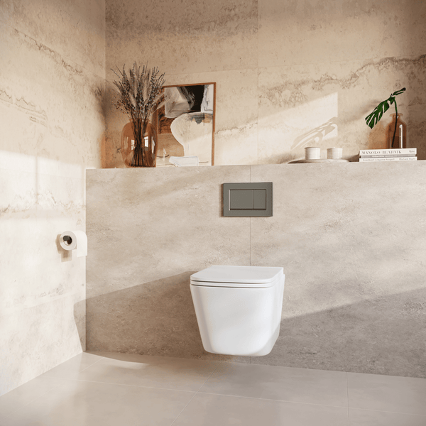 Modernes wandhängendes WC mit Spülbetätigungsplatte vor einer gefliesten Wand in einem hellen Badezimmer mit Dekorationsgegenständen