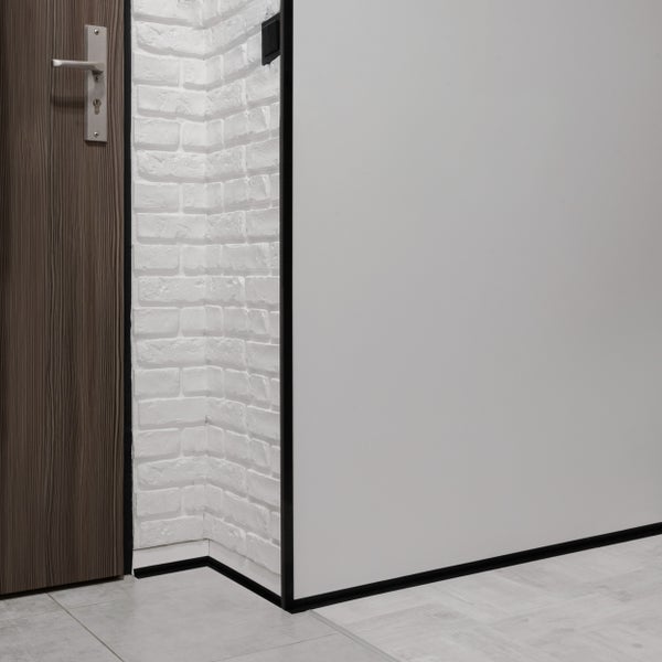 Detailansicht eines modern gestalteten Zimmers mit einer Holztür, einer weißen Backsteinwand und einer glatten Wand