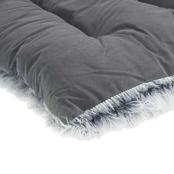 Dunkelgraues gepolstertes Kissen mit weichem Stoffbezug und flauschigem Rand aus weiß-grauem Kunstfell.