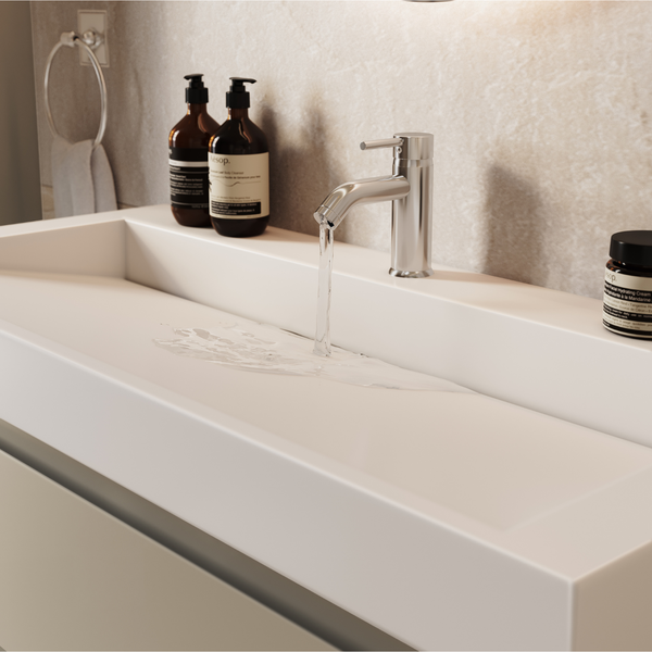 Modernes Waschbecken mit Einhebelarmatur und fließendem Wasser in einem minimalistischen Badezimmer.