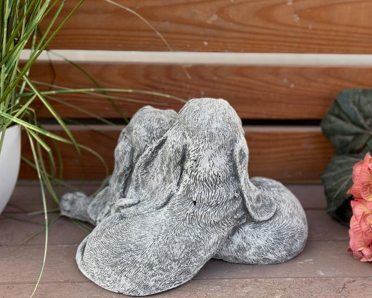 Gartenfigur aus Steinguss: Zwei kuschelnde Hasen von hinten dargestellt.