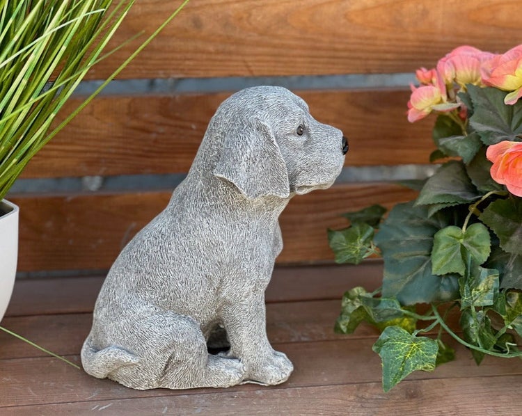 Gartenfigur sitzender Welpe aus Steinguss in Steinoptik.
