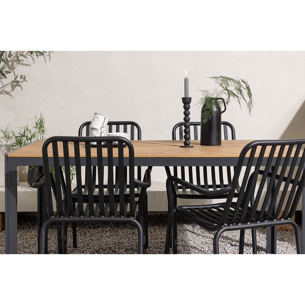 Gartentisch mit schwarzen Stühlen, Kerzenständer und Dekoration für den Außenbereich.