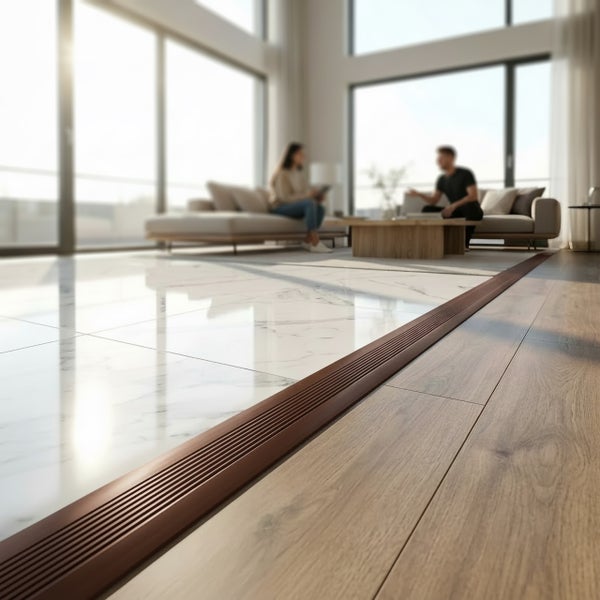 Bodenprofil aus Kunststoff verbindet Fliesen und Holzboden in einem hellen Wohnraum.