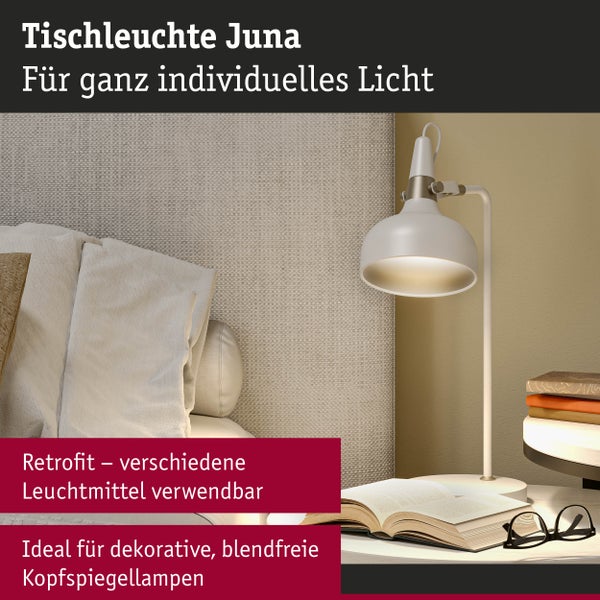 Tischleuchte Juna neben einem Bett mit einem offenen Buch und einer Brille auf einem Nachttisch.