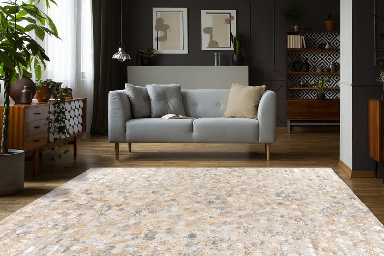 Großer Teppich mit hexagonalem Mosaikmuster in Beige und Grau in einem modernen Wohnzimmer mit grauem Sofa, Holzmöbeln und Zimmerpflanzen.