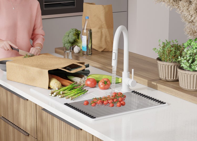 Küchenszene mit frischem Gemüse, Spüle und Armatur.