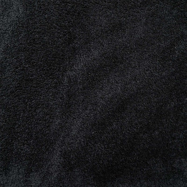 Schwarzer Hochflor-Teppich mit weicher Oberflächenstruktur in der Nahaufnahme.
