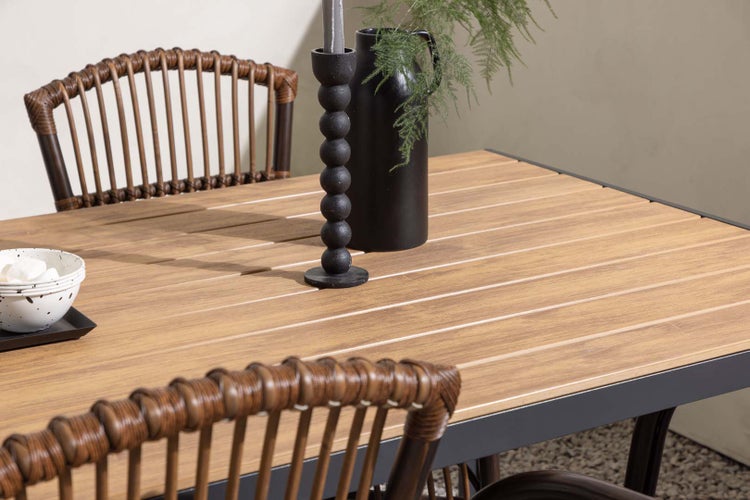 Nahaufnahme eines Gartentisches mit Stühlen, Dekoration und Geschirr.