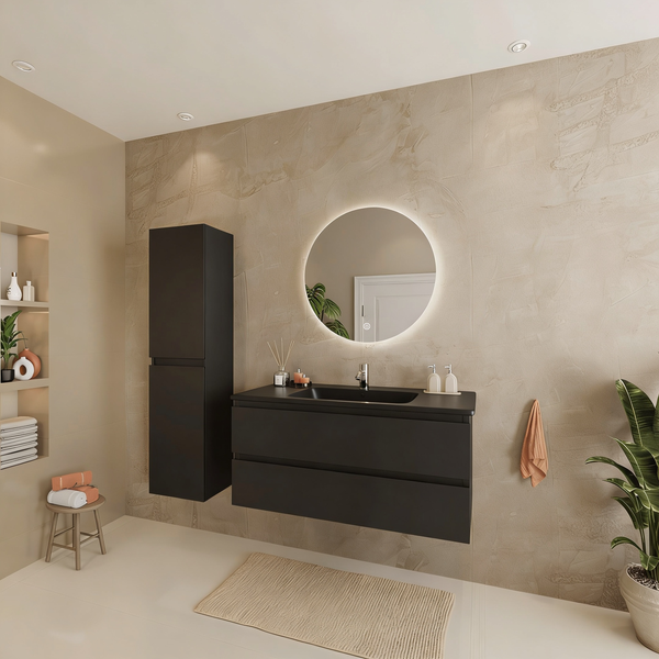 Modernes Badezimmer mit dunkelgrauem Wand-Waschtisch, Hochschrank und rundem, hintergrundbeleuchtetem Spiegel an einer Wand in Steinoptik.