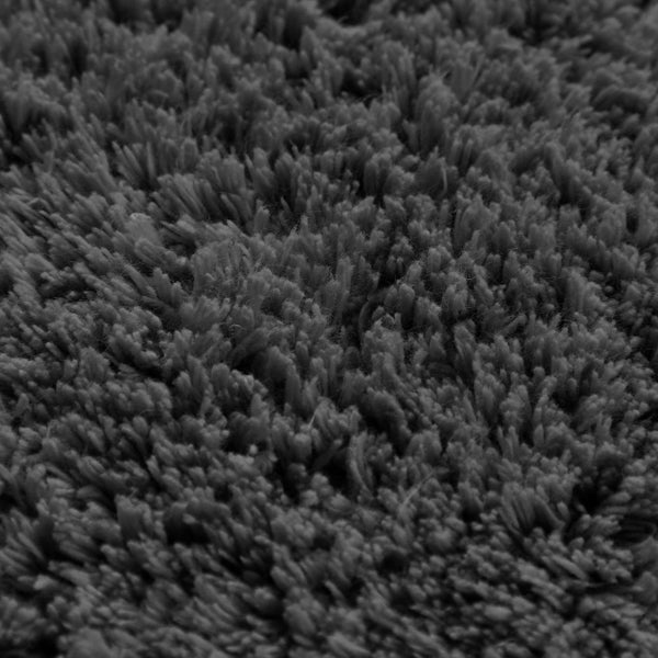 Gerollte graue Badematte aus 100 Prozent Baumwolle mit einer Detailansicht der weichen Textur.