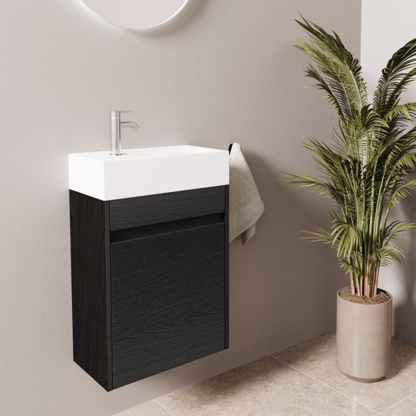 Wandhängender Waschtischunterschrank mit Waschbecken und Armatur in einem modernen Badezimmer mit Pflanze.