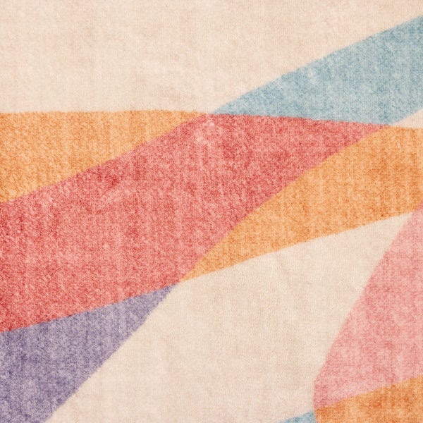 Nahaufnahme eines weichen Teppichs mit geometrischem Muster in verschiedenen Farben.