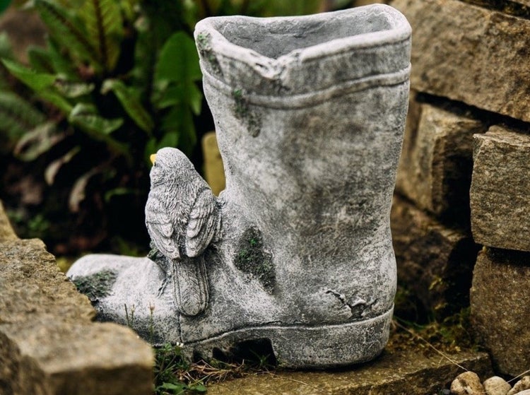 Pflanzgefäß in Stiefelform mit Vogel aus Stein für den Garten.