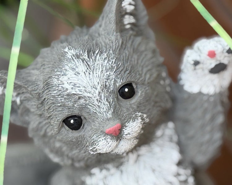 Grau-weiße Deko-Katzenfigur aus Kunststein mit erhobener Pfote für den Garten