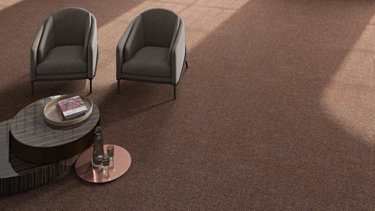 Strukturierter Teppichboden in einem hellen Wohnzimmer mit zwei grauen Sesseln und einem modernen Couchtisch.