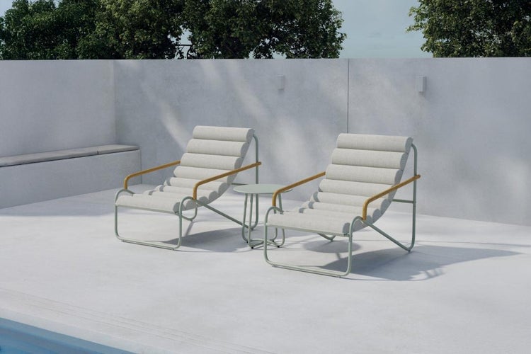 Zwei moderne Garten-Loungesessel mit Metallgestell, Holzarmlehnen und hellen Polstern auf einer hellen, minimalistischen Terrasse mit Beistelltisch.