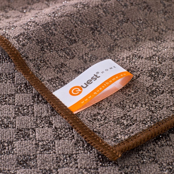 Teppich mit brauner Bordüre und Quest Home Logo