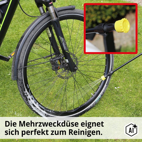 Eine Mehrzweckdüse zur Reinigung eines Fahrradreifens auf einer Grasfläche.