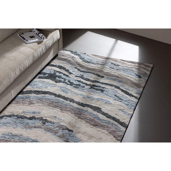Dekorativer Teppich mit abstraktem Muster neben einem Sofa