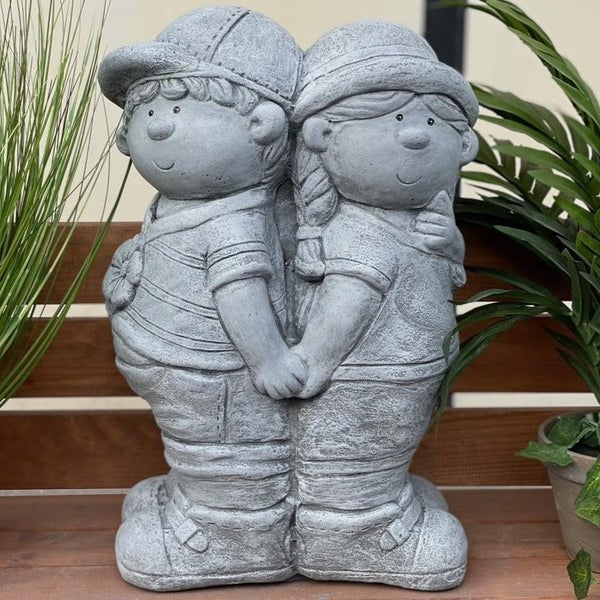 Gartenfigur Kinderpaar aus Steinguss, zwei sich an den Händen haltende Kinder mit Kopfbedeckungen als dekorative Dekoration für den Außenbereich.