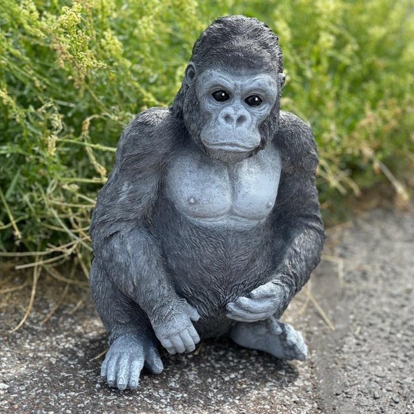 Dekorative Gartenfigur in Form eines sitzenden Gorillas aus wetterfestem Kunststein für den Außenbereich.