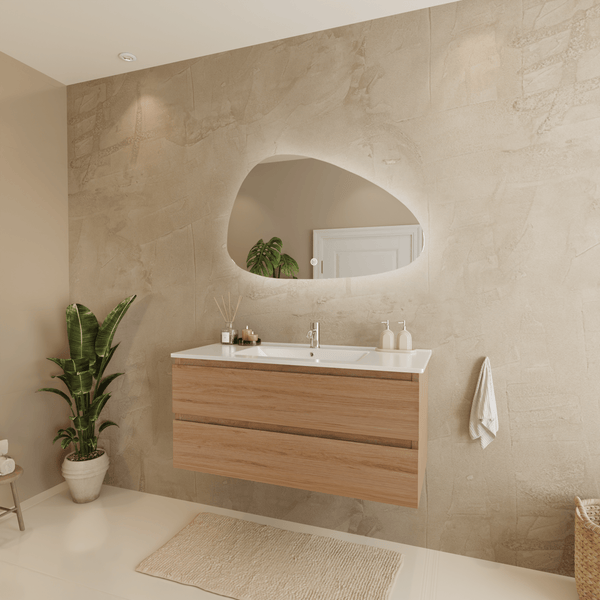 Modernes, helles Badezimmer mit hängendem Holz-Waschbeckenunterschrank, Waschtisch, organisch geformtem LED-Spiegel und strukturierter Wand.
