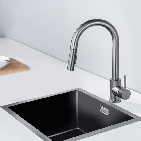 Moderne Küchenspüle aus Edelstahl mit passender Küchenarmatur mit ausziehbarer Brause auf einer hellen Arbeitsplatte.