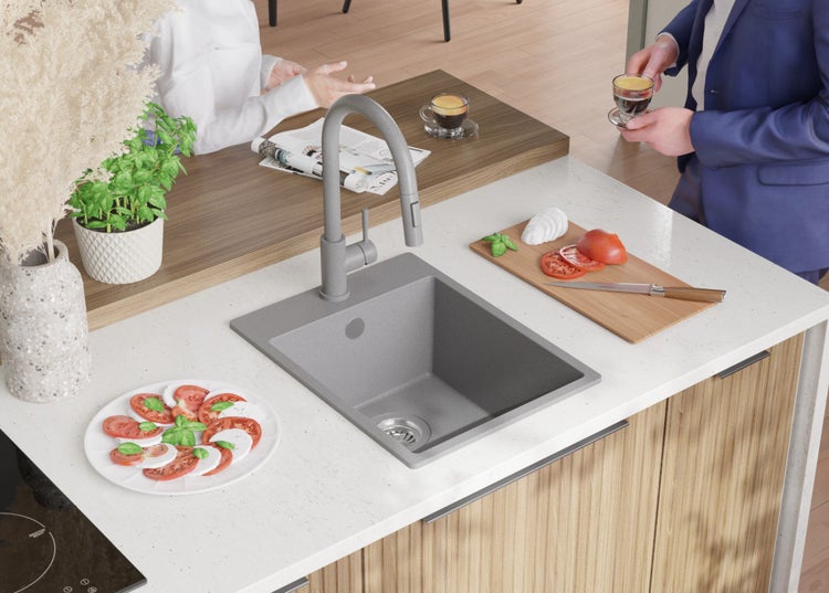 Küchenszene mit Spüle, Armatur, Arbeitsplatte, Kochfeld und Personen