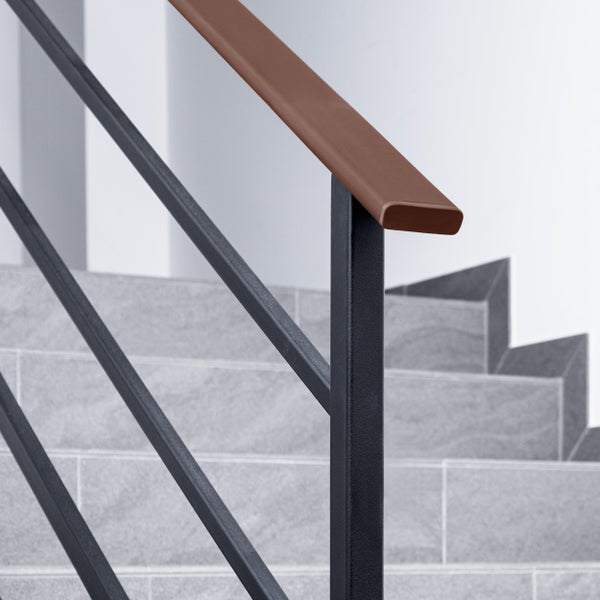 Treppengeländer mit braunem Handlauf und dunklen Metallpfosten auf einer Treppe mit grauen Fliesen.
