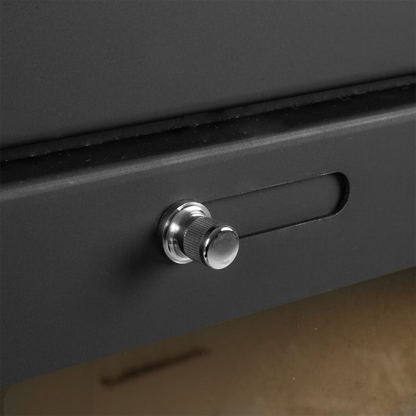 Nahaufnahme eines Luftschiebers aus Metall an einem Kaminofen zur Regulierung der Luftzufuhr.