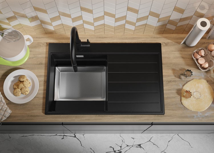 Spüle aus schwarzem Material mit Abtropffläche, inklusive Küchenarmatur und Spülbecken, in einer Küche mit Backutensilien.