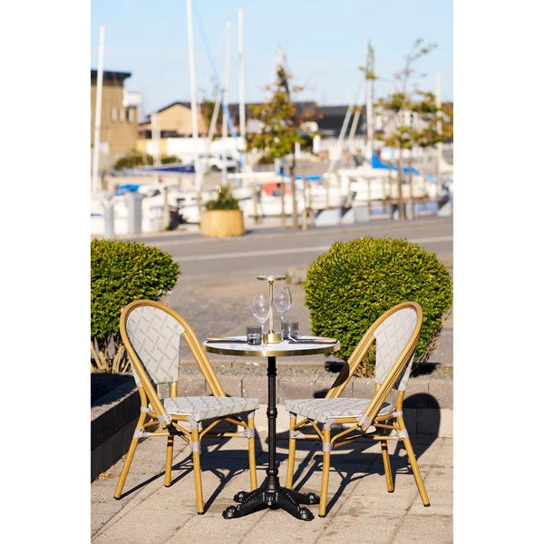 Tisch mit zwei Stühlen im Außenbereich mit Blick auf einen Yachthafen