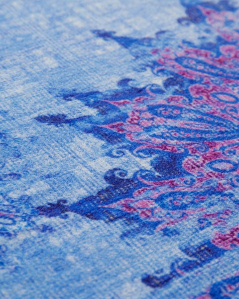 Nahaufnahme eines Teppichs mit orientalischem Muster im Vintage-Stil, flachgewebte Textiloberfläche.