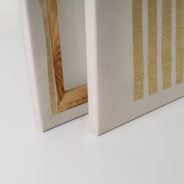 Nahaufnahme von zwei Leinwandbildern mit Holzrahmen und abstrakten goldenen Streifen