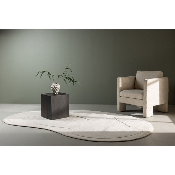 Szene mit Teppich, Sessel und Beistelltisch mit Dekoration