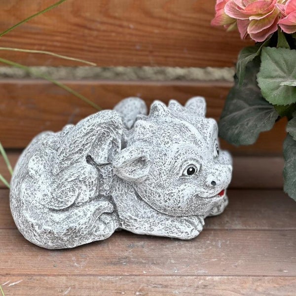 Gartenfigur in Form eines kleinen, liegenden Drachens in Steinoptik.