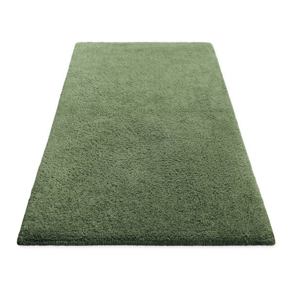 Rechteckige grüne Badematte mit flauschiger, langfloriger Oberfläche.