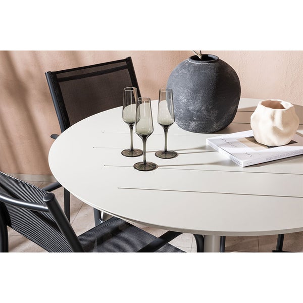 Szene mit rundem Gartentisch, Stühlen, Gläsern und Dekoration