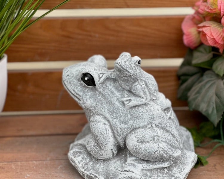 Gartenfigur aus Steinguss in Form eines grossen Frosches mit einem kleineren Frosch auf dem Ruecken.
