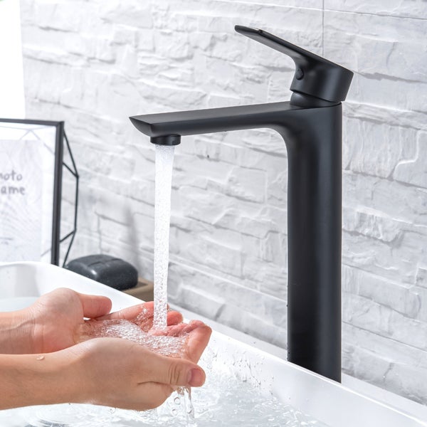 Hohe Waschtischarmatur in mattem Design mit Einhebelmischer und fließendem Wasser über den Händen in einem modernen Badezimmer.