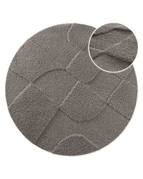 Runder grauer Hochflor-Teppich mit geometrischem Muster aus Quadraten und Bögen sowie Detailansicht der Struktur.