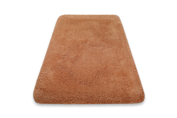 Rechteckige Badematte mit abgerundeten Ecken und weichem Hochflor in Terracotta.