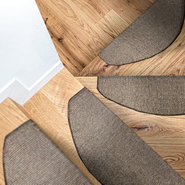 Stufenmatten auf einer geschwungenen Holztreppe aus Eiche in einer modernen Wohnumgebung