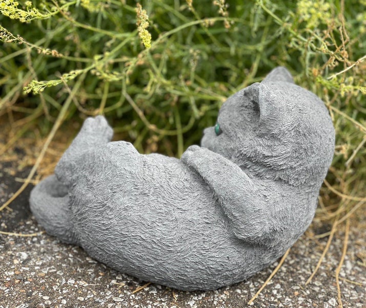 Dekorative Katzenfigur aus Stein für den Garten liegend