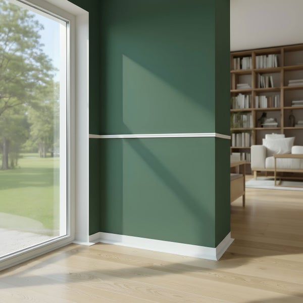 Innenraum mit grüner Wand, weißen Zierleisten und einem Fenster mit Blick ins Grüne.