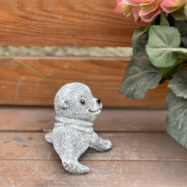 Kleine dekorative Robbenfigur aus Stein mit strukturierter Oberfläche.